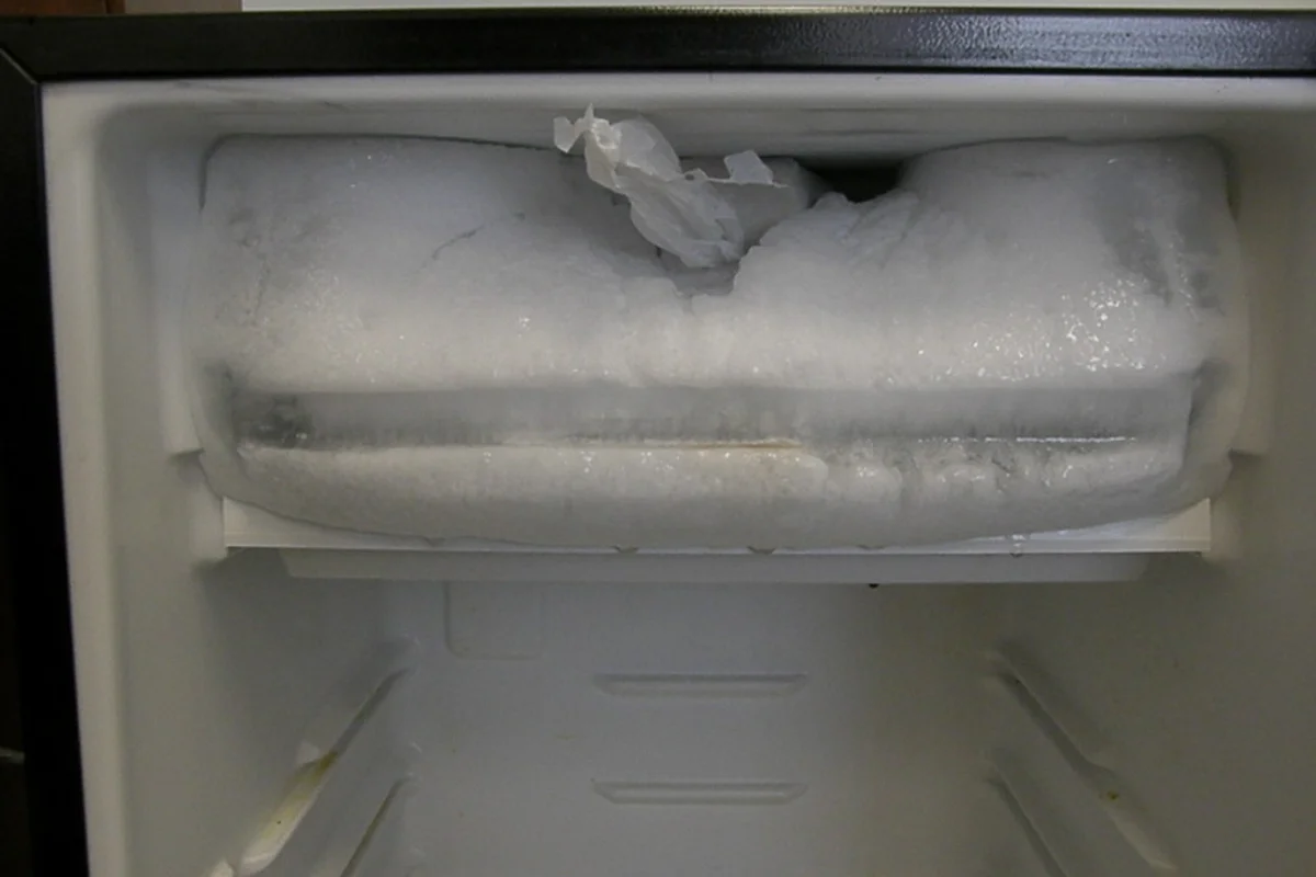 Domestic freezer compartment undergoing defrosting to melt and clear accumulated internal ice.
