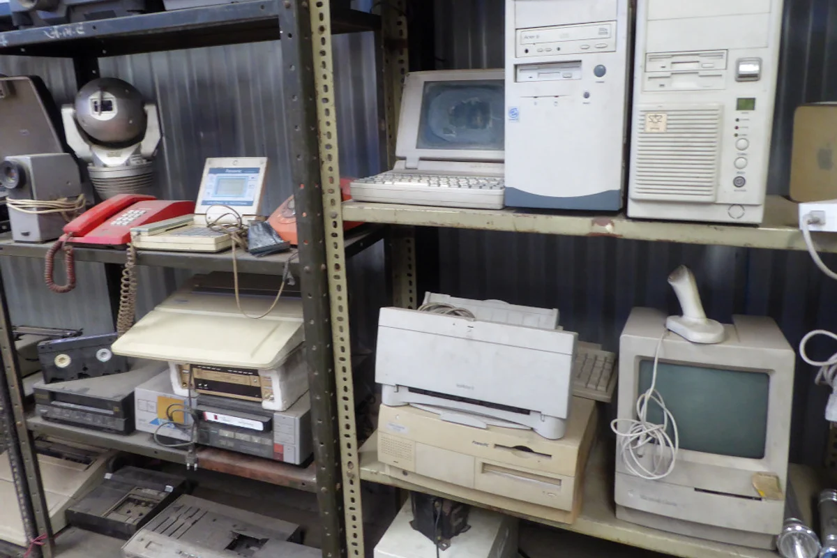 A collection of redundant office printers and electronic hardware awaiting pickup and recycling.