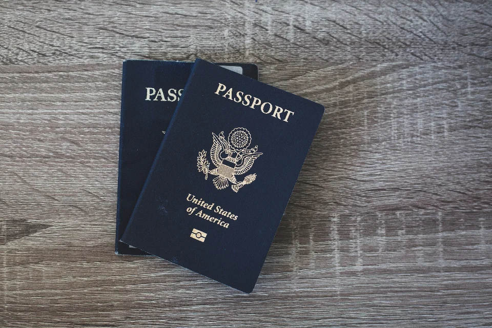 Two passports set aside on a wooden table, kept back before a home is cleared.