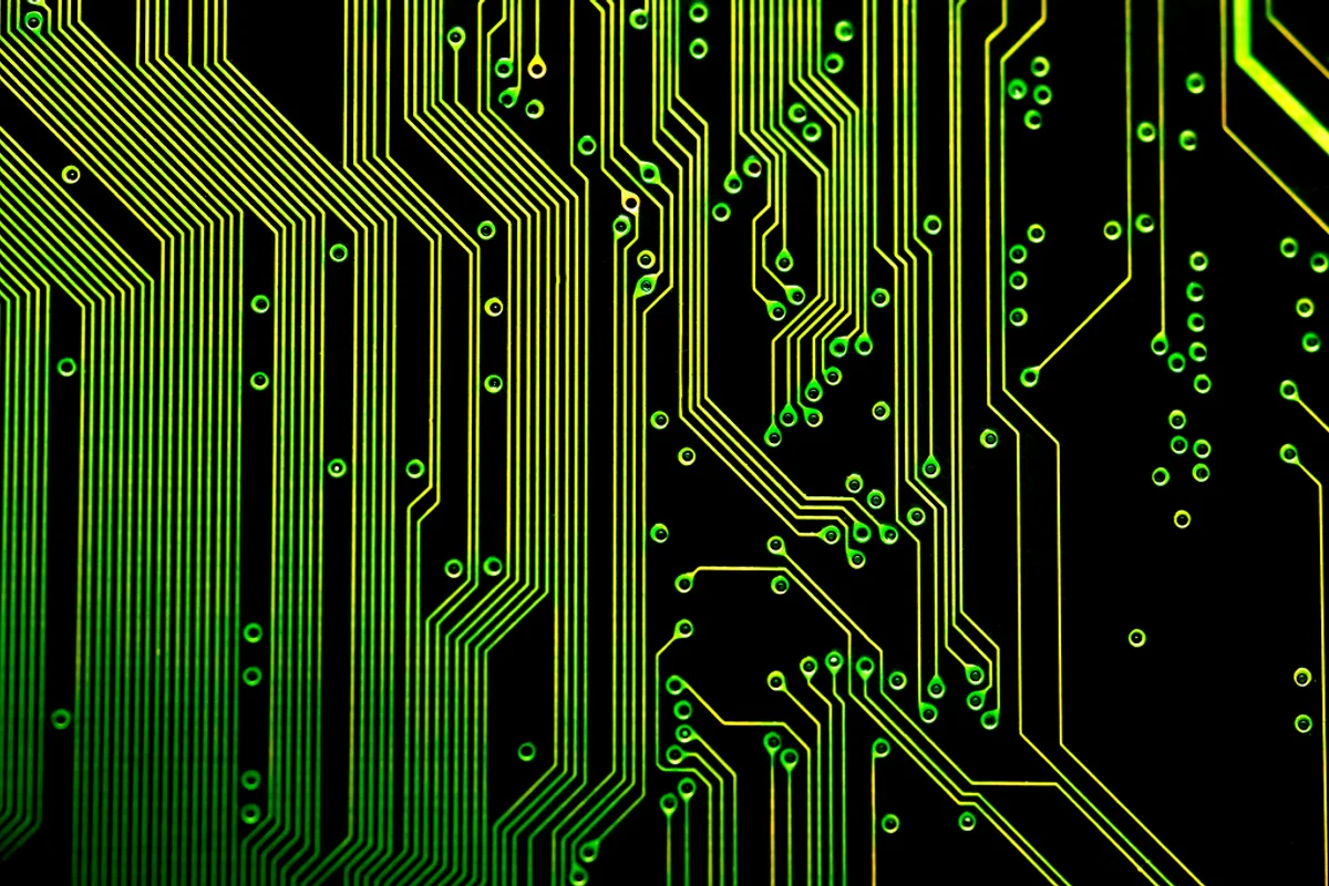 Close-up of a printed circuit board with metallic conductive tracks and electronic components.
