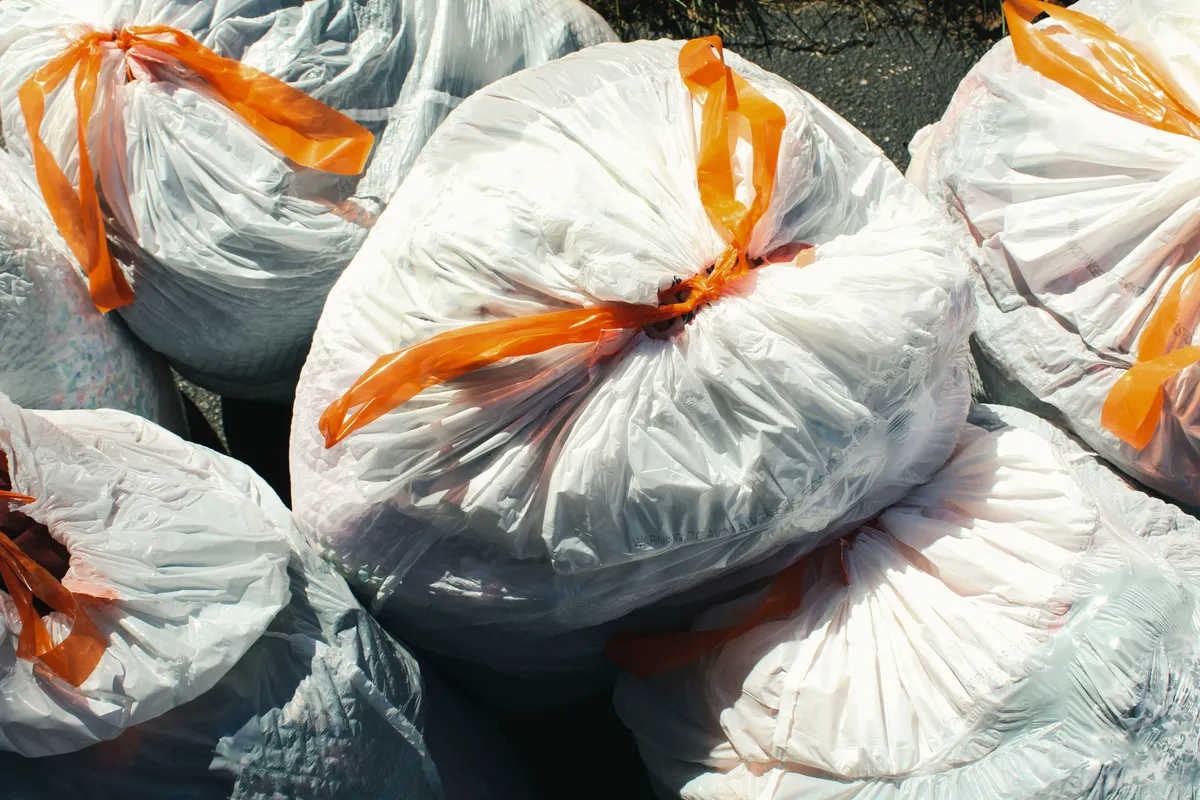 Household garbage bags tied and gathered together, ready for collection.