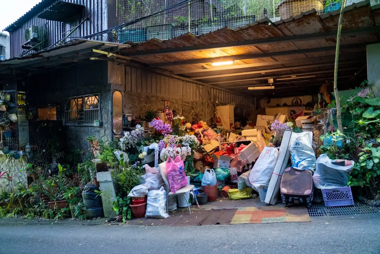 A home garage overflowing with household items, boxes and clutter stacked against the walls.