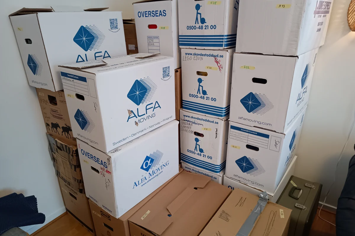 Cardboard moving boxes neatly stacked in an apartment living area during domestic relocation preparation in Dubai.