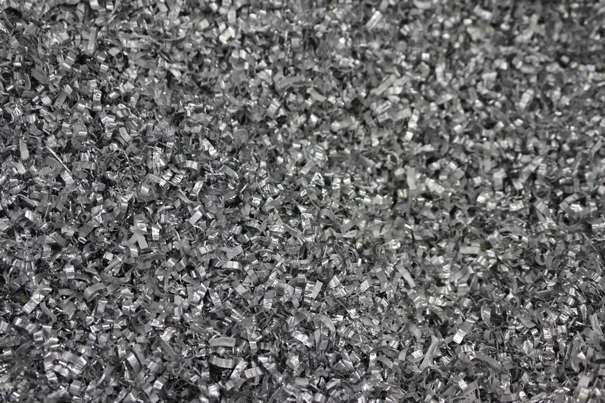 A dense, close-up pile of shredded metallic scrap swarf and shavings ready for smelting.