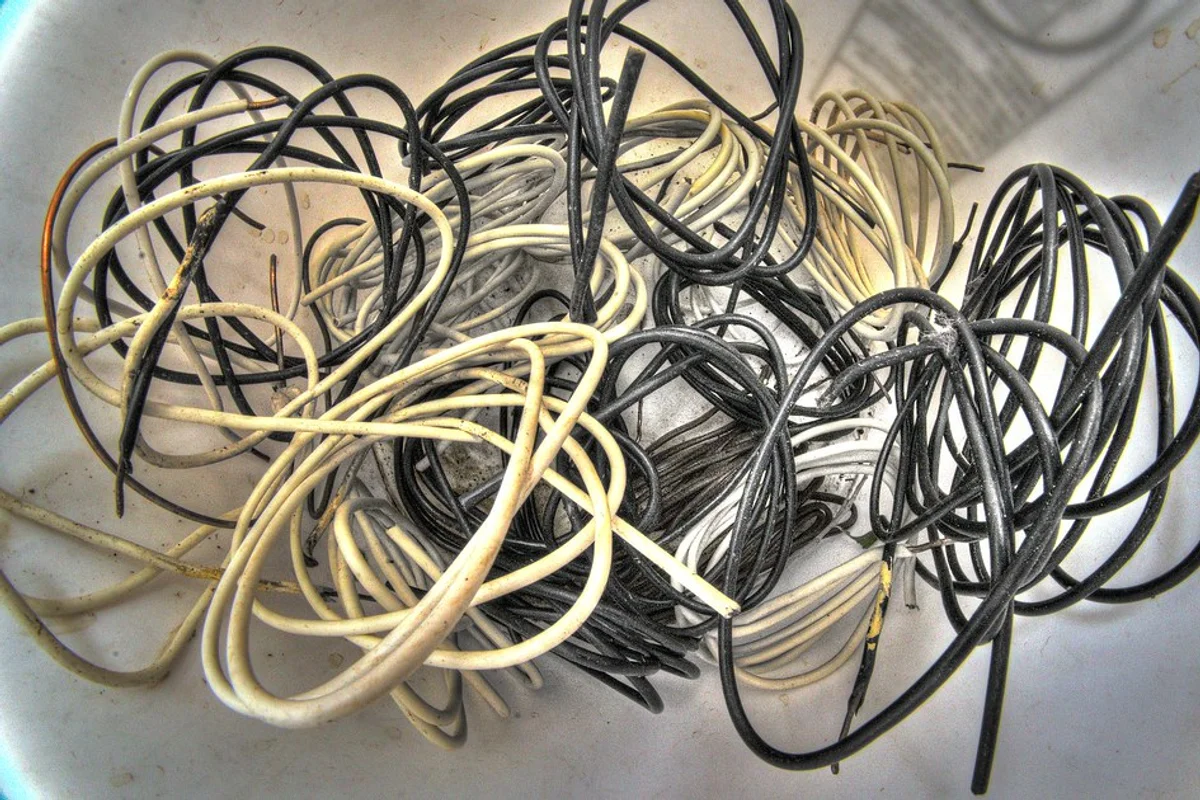 Stripped power cables, electrical cords, and copper wiring separated into bins for material recovery.