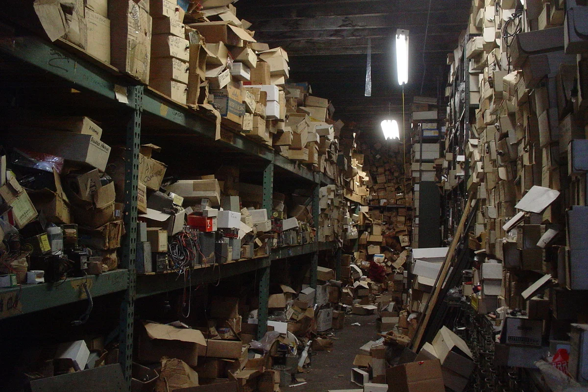 Accumulated household storage boxes, plastic crates, and miscellaneous items stacked tightly in a home storeroom.