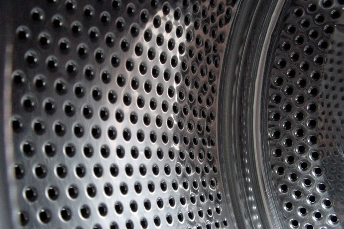 Close-up view of a stainless steel washing machine drum and rubber door seal.